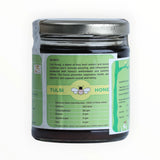 Jar of Tulsi honey with a green label on a white background